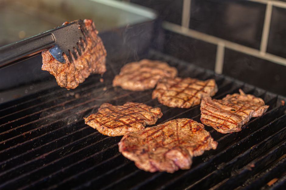 Carne asada tacos sizzling on the flat-top